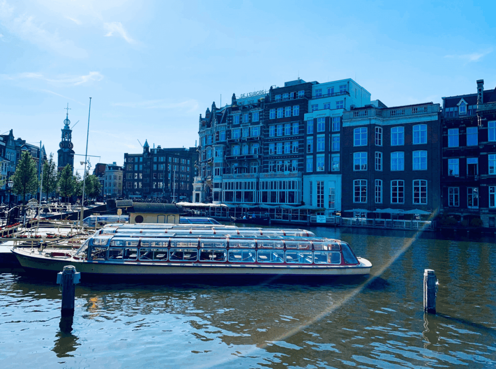 Aussicht auf ein Boot in einem Kanal der in einem Amsterdam Reiseführer dargestellt wird