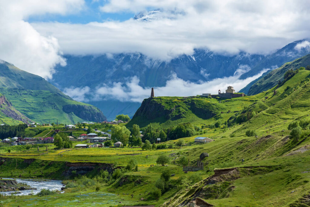 Grüne Landschaft mit Bergen und Wolken aus einem der besten Georgien Reiseführer Empfehlungen