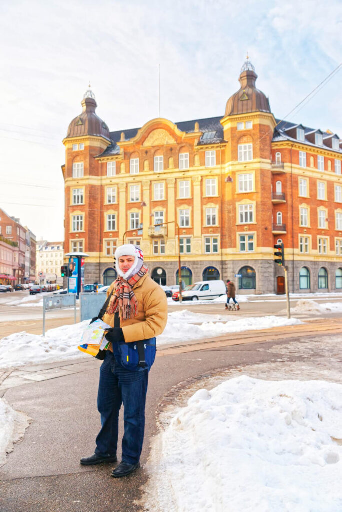 Man hält empfohlenen Kopenhagen Reiseführer im Stadtzentrum in der Hand