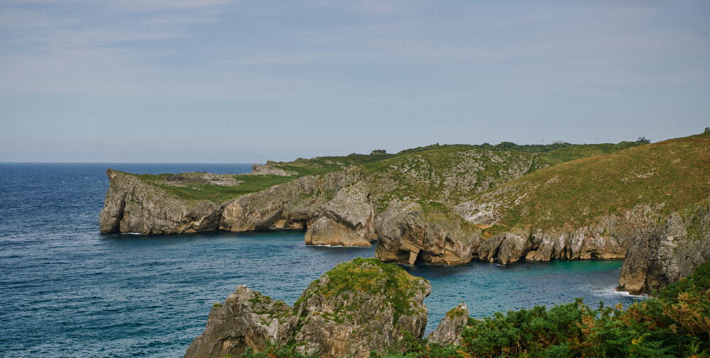 Grüne bewachsene Küste in Nordspanien mit blauem Wasser und Natur